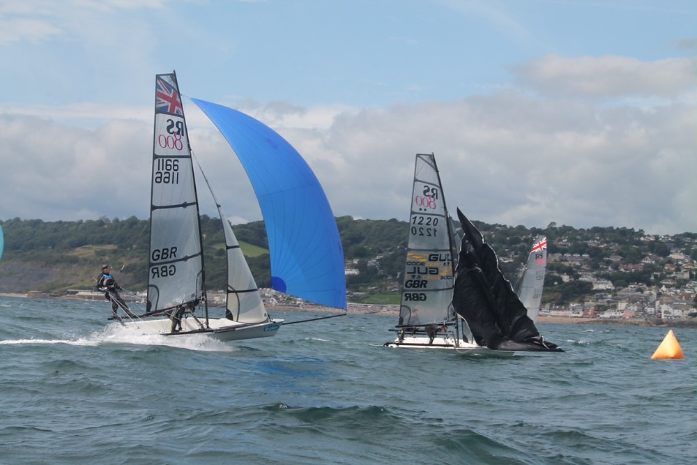 Lyme’s Cameron and Darroll Moss, left, pursue the leaders Luke and Emma McEwan, at the leeward mark as spinnakers are dropped. Photo by Jess Douglas