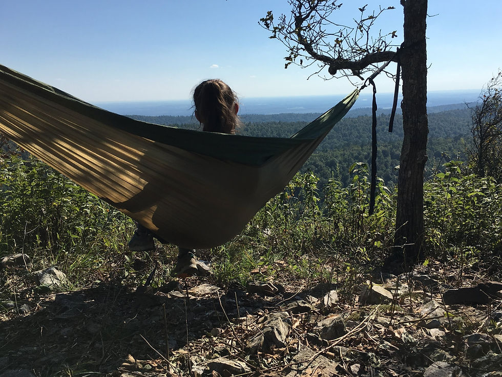 woman sitting in her hammock looking off at the view