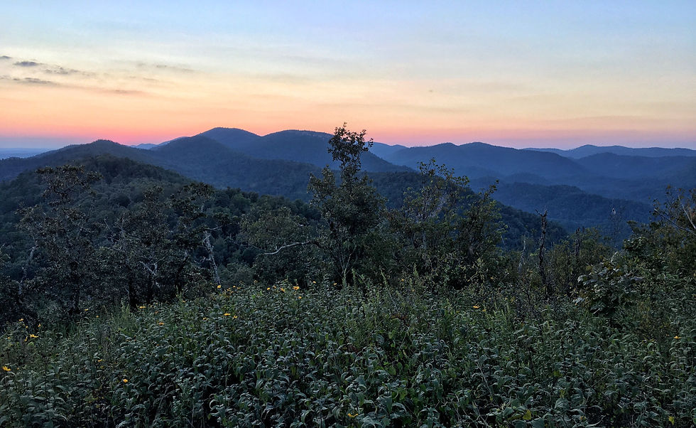 Eagle Rock Loop on Brush Heap Mountain. Sun has set behind the mountains leaving behind a pink glow framing the blue mountain ridges