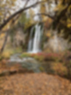 spearfish falls waterfall surrounded by yellowing trees