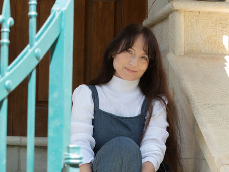 ויקי יושבת בכניסה על המדרגות, מאחוריה דלת 