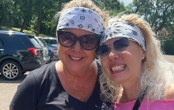 two girlfriends smiling in pink support squad tshirts