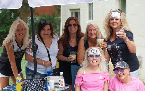 Group of women holding shots and smiling at picnic table