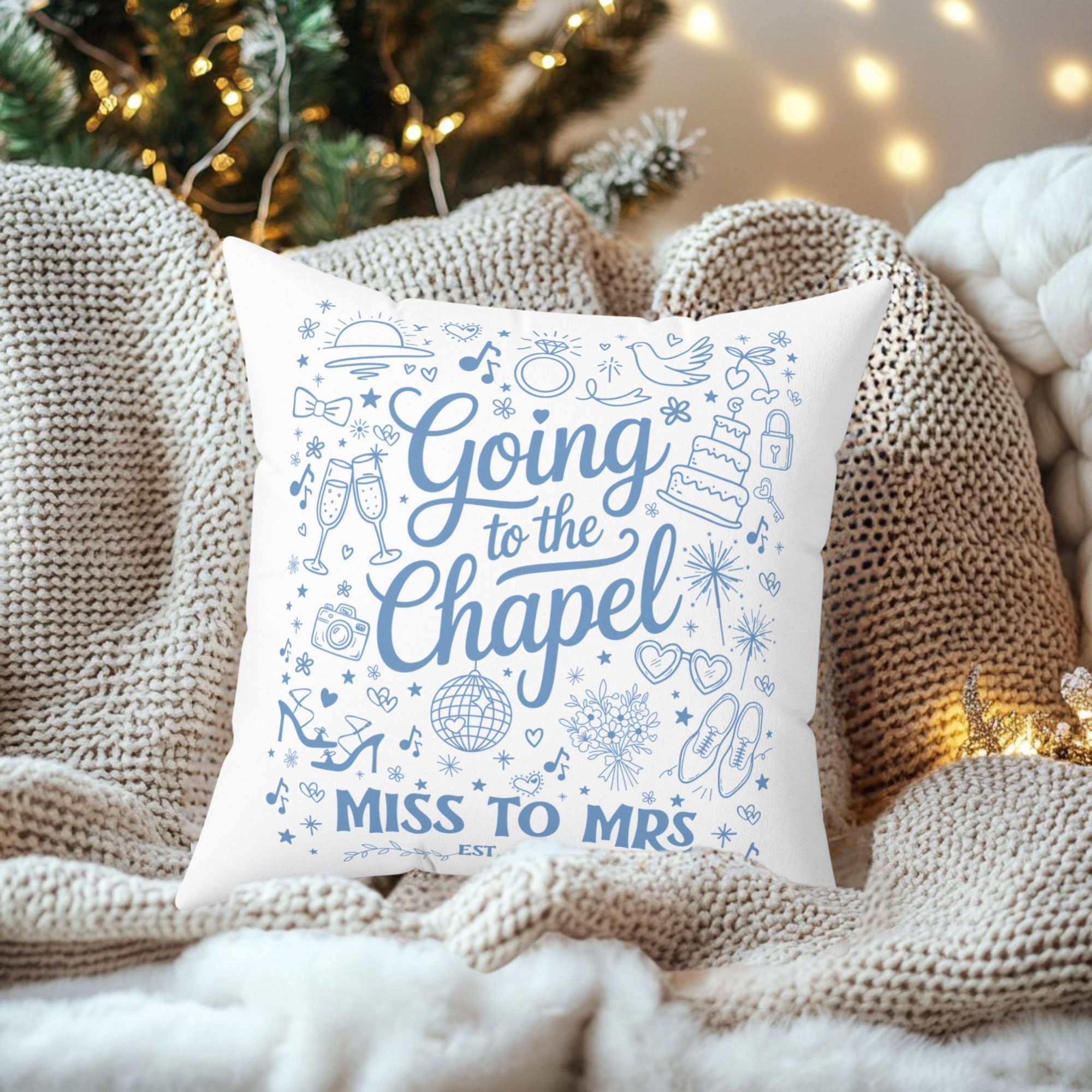 White pillow with "Going to the Chapel, Miss to Mrs" over knitted blanket.