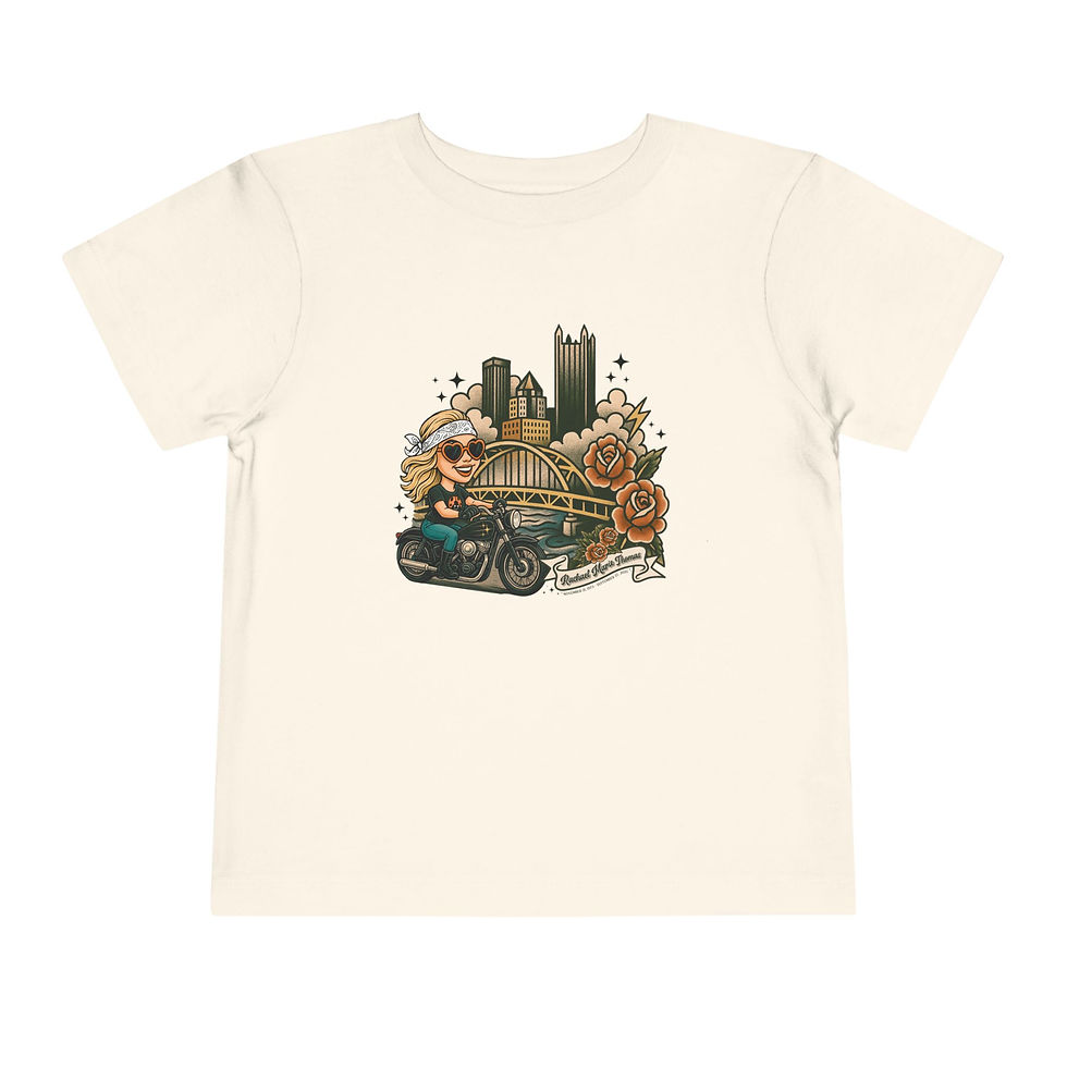 Thumbnail: Toddler tee with cartoon biker, city skyline, and flowers. Remembering Rachael Thomas 2025 Memorial Toddler Tee