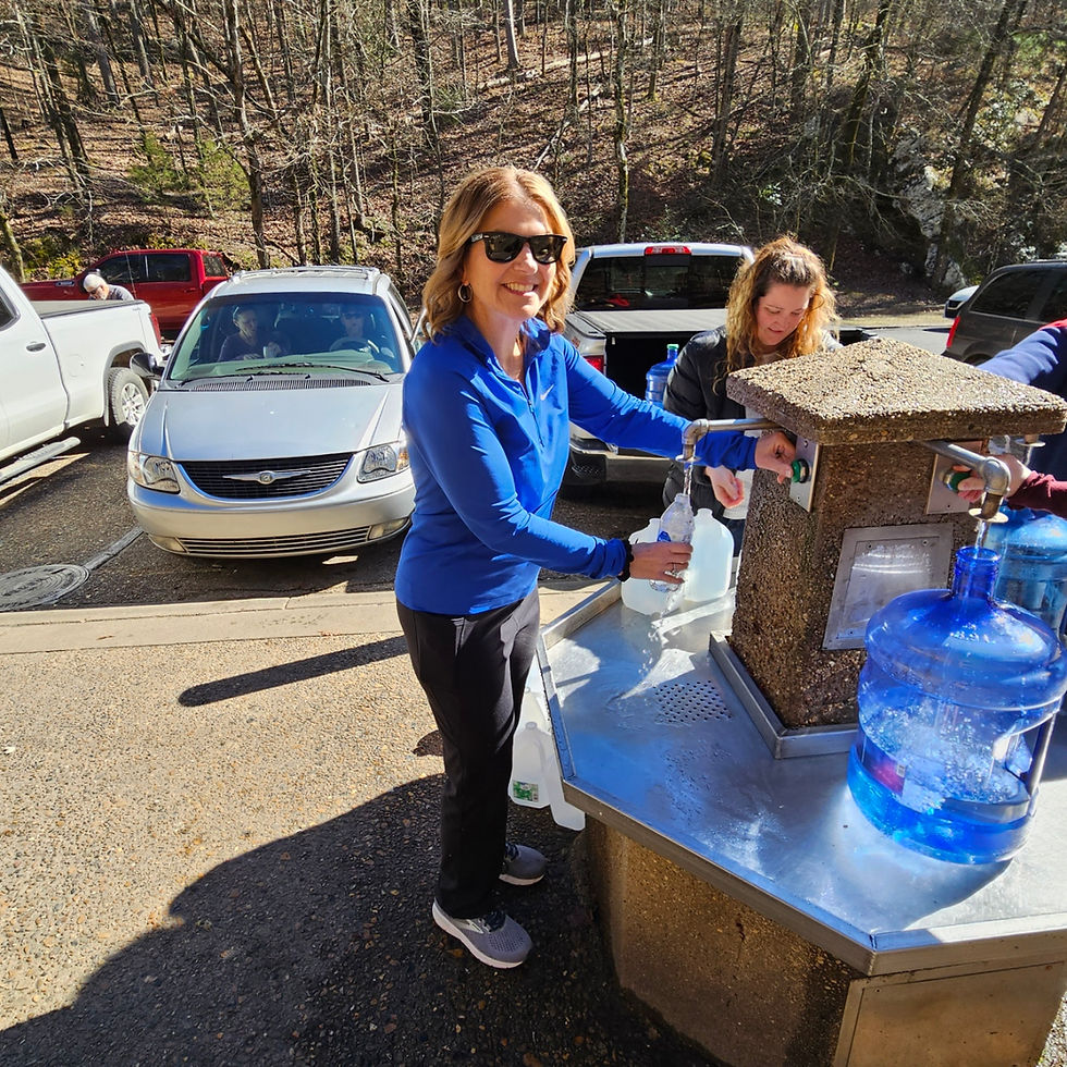 Lisa feels her water bottle at a natural springs spigot.