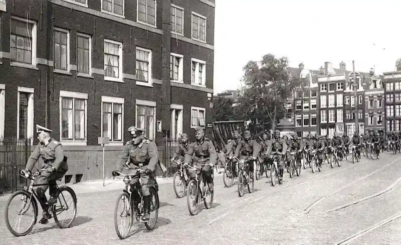 Amsterdam, Prins Hendrikkade, May 1940. Nazis cycle through occupied Amsterdam.