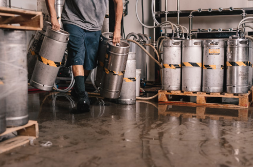 Man carrying kegs in a West Palm Beach brewery.