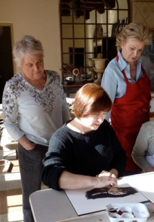 Suz Landay and Kerstin Royce look over Deb Shaw's shoulder during a demonstration.