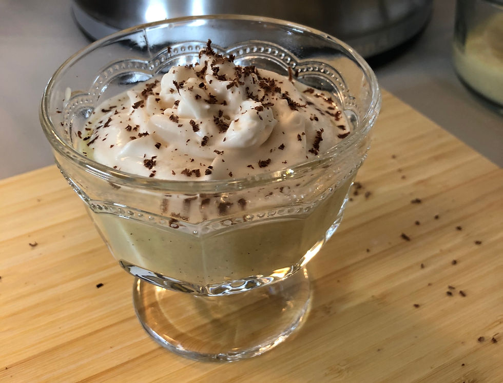 white chocolate oat milk pudding in mini trifle dish topped with whipped cream and shaved chocolate