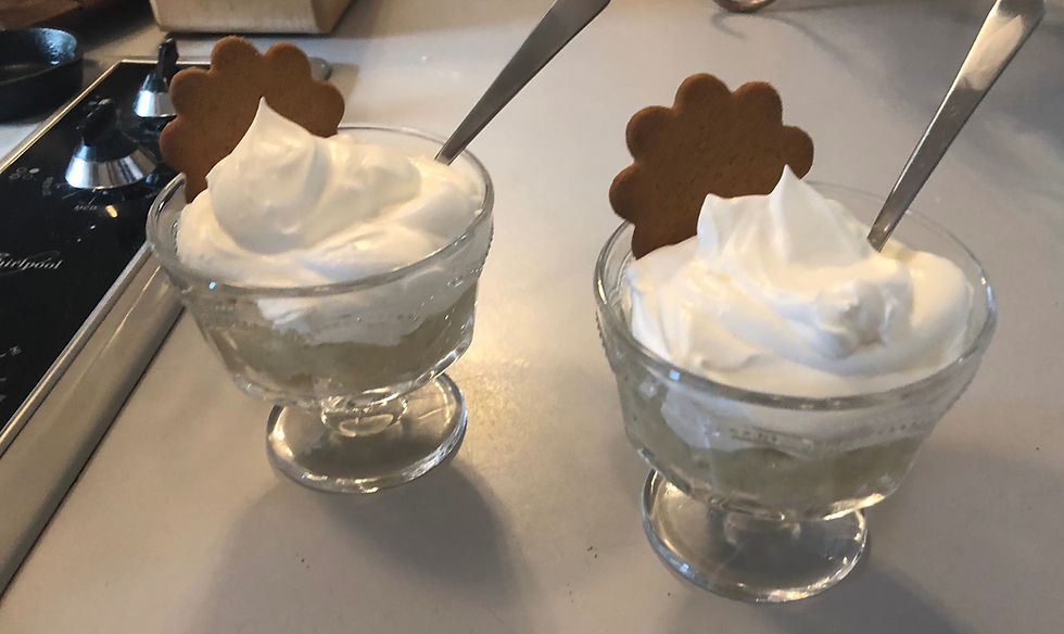 two mini trifle dishes with white chocolate oat milk pudding, topped with whipped cream and cookies