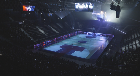 L'ensemble de la scène et des écrans autour du terrain de jeu sont illuminés par des projections animées, renforçant l'impact visuel et immersif du spectacle.