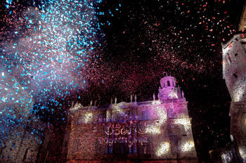 Un spectacle de confettis éclate sous les lumières du bâtiment illuminé, ajoutant une dimension festive à cette aventure visuelle.
