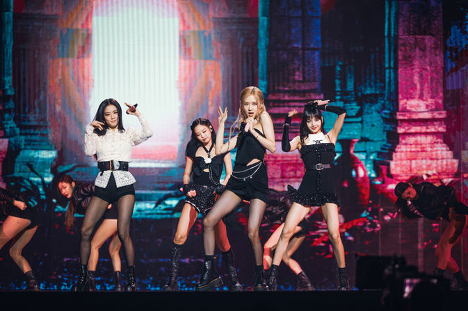 Blackpink en pleine chorégraphie énergique, se produisant devant des décors visuels dynamiques qui accentuent le rythme de leur prestation scénique.