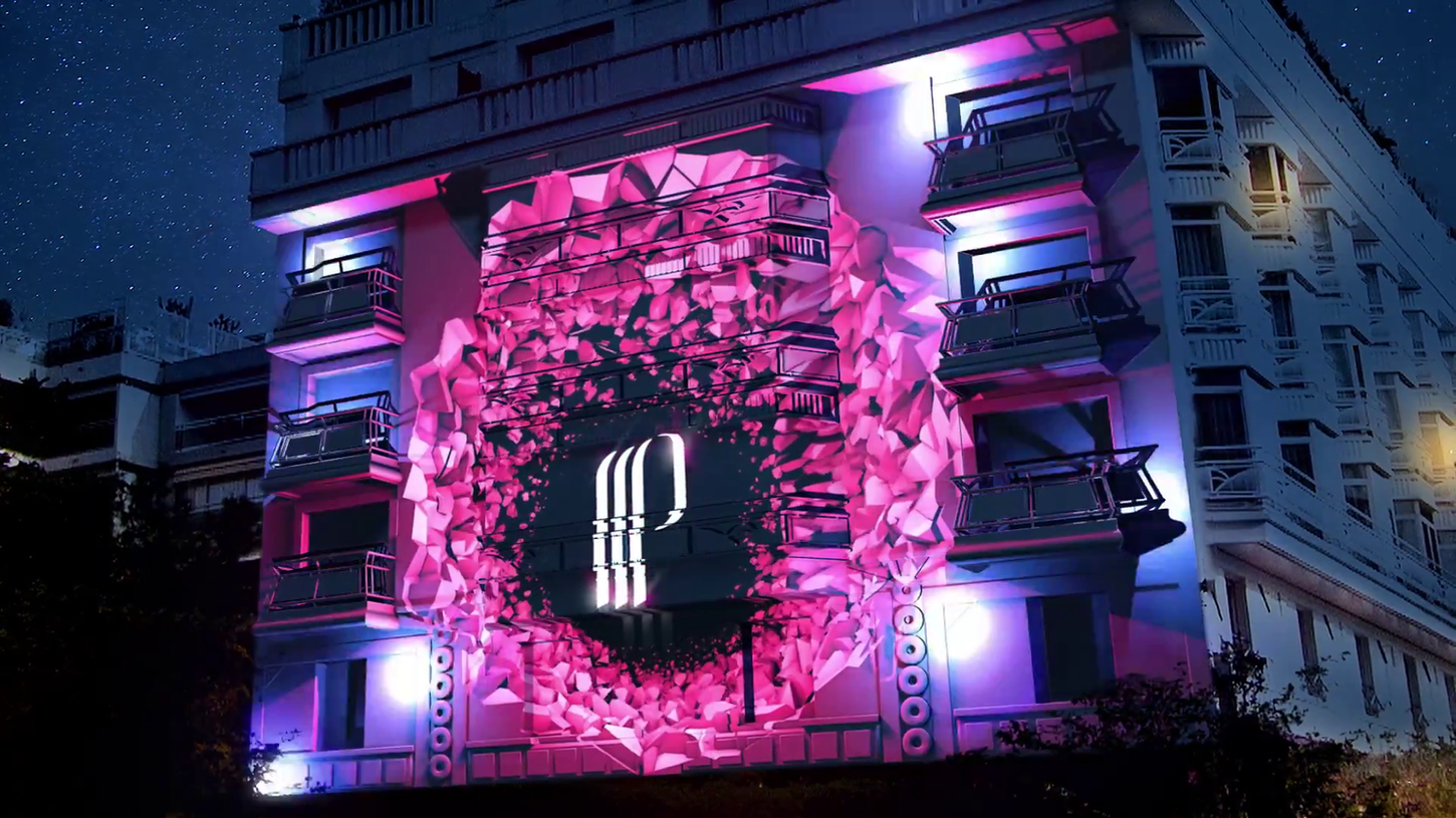 Une explosion visuelle spectaculaire éclate au centre de la façade, créant un effet de dynamisme et de mouvement. Les éclats géométriques se dispersent autour d’un symbole central, représentant l’énergie vibrante des jeux de casino.