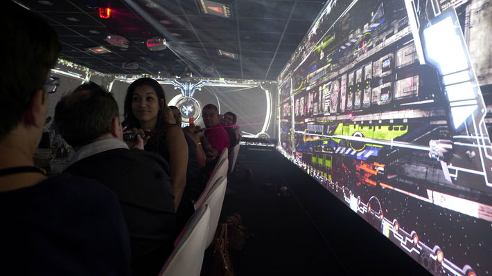 Les clients prennent place dans un cadre futuriste, entouré de projections vidéo 360°, leur offrant une immersion totale dès leur entrée. L’atmosphère rappelle celle d’un vaisseau spatial, avec des éléments technologiques modernes et des effets spéciaux captivants.