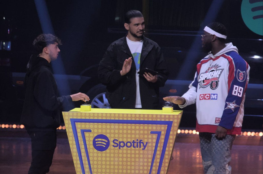 Aminematue, Inoxtag et Dinos discutent autour d'un podium sponsorisé par Spotify. Ils échangent des réponses dans le cadre du jeu en direct "Best of Five", animé par @Aminematue.