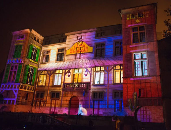 Projection du décor de banque typique du Far West sur le château, avec des détails architecturaux rappelant un village de l'époque, transportant les spectateurs dans une autre époque.