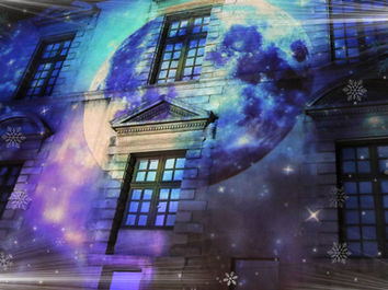 Une immense projection de la lune apparaît sur la façade, entourée d’un ciel étoilé scintillant. Ce tableau spectaculaire transporte les spectateurs dans une scène onirique, avec des effets lumineux qui évoquent la magie et le rêve, parfaits pour la période de Noël.