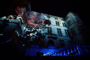 Les murs du château s’effondrent en projection pour illustrer les ravages causés par la guerre. La reconstruction symbolisée par les jeux de lumière met en avant l’espoir de la renaissance après tant de destruction.