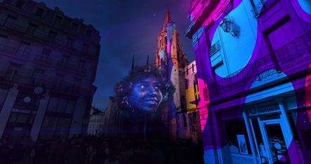 Une scène mettant en lumière un visage géant projeté sur un bâtiment, entouré de notes de musique et de couleurs éclatantes. Ce moment poétique et joyeux a captivé le public, transporté dans un univers visuel et sonore unique.
