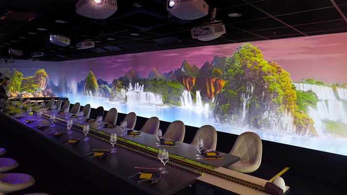 Les invités sont immergés dans un paysage naturel, entourés de cascades et de montagnes verdoyantes. Cette projection paisible crée une atmosphère relaxante et harmonieuse, idéale pour profiter d’un repas dans un cadre immersif et serein.