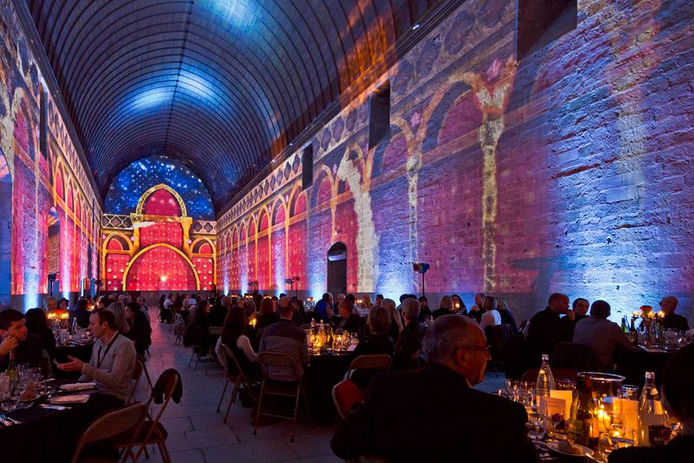 Perspective de la salle, montrant l’ampleur de la reconstitution immersive et l'architecture majestueuse, recréée par des projections de lumière.