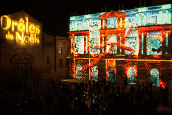 Séquences de lumières rouges et vertes évoquant des décorations de Noël, enveloppant la mairie dans une atmosphère chaleureuse.