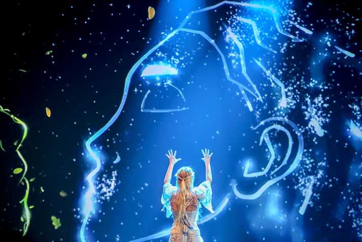 La scène s’ouvre avec une silhouette lumineuse, dessinée par des projections magiques, plongeant immédiatement le public dans l’univers féérique du conte d’Andersen. Ce visuel captivant instaure une atmosphère de mystère et de magie.