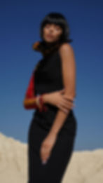 Wyne Kirabo Closer view of Ensigo (seed in english) long black dress with one sleeve long on a Kikoi fabric and sleeveless on the other arm from Roots Collection 