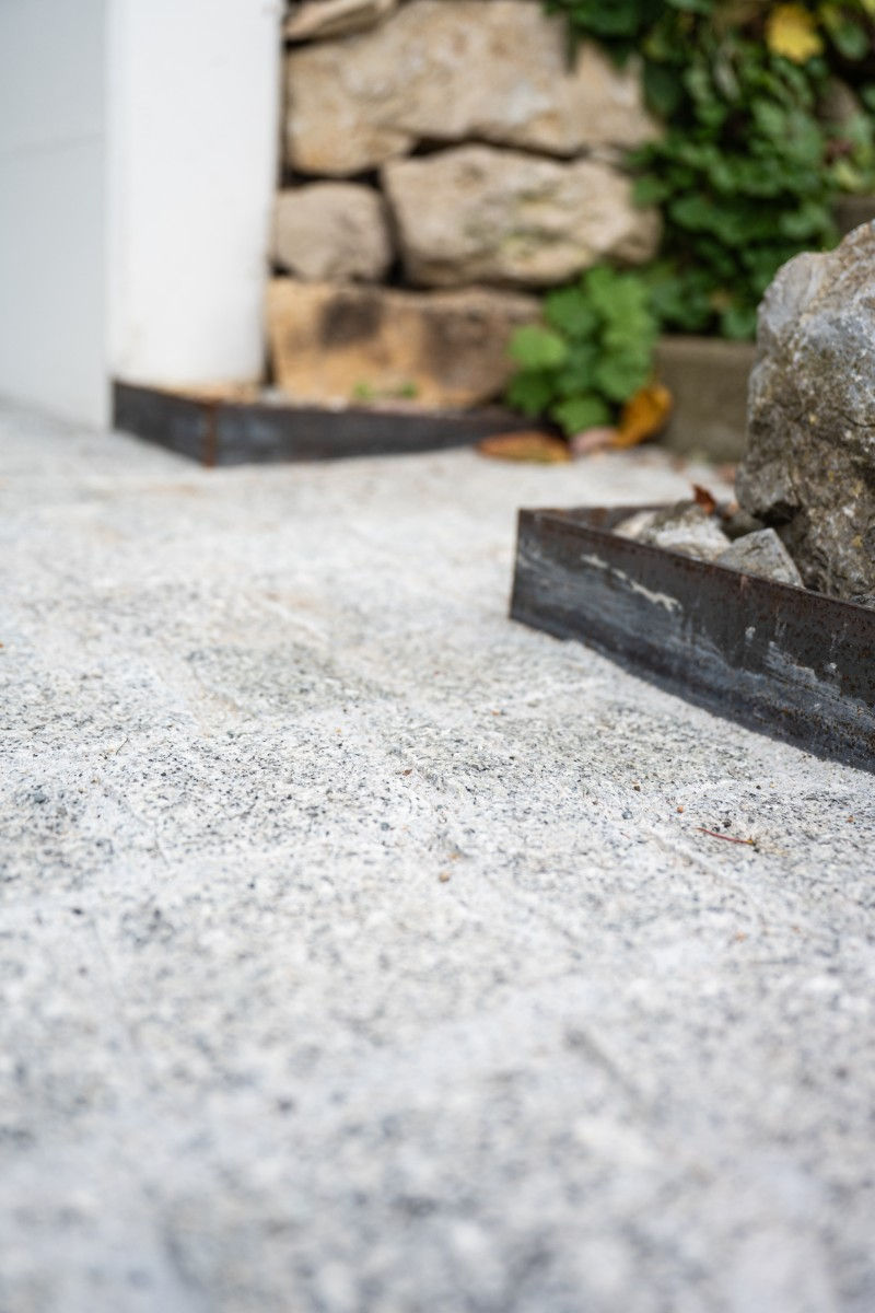 Driveway and parking area with precise steel edging.