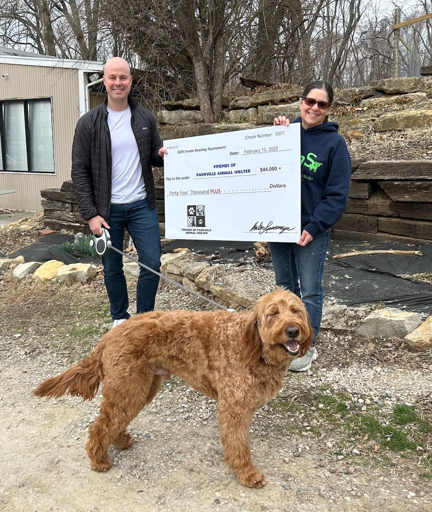 Senator Tony Luetkemeyer and dog Truman pose for a picture with long-time FOPAS volunteer Maria Mignogna.