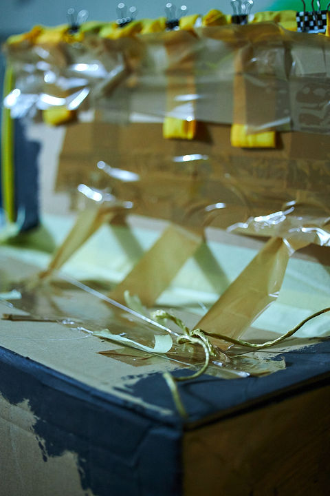 Klebeband hält ein gebasteltes Fenster aus Papier zusammen.