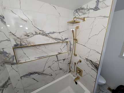 fancy marble shower with gold trim and gold accents