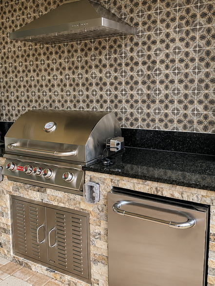 Outdoor kitchen with built-in grill, sink, and refrigerator