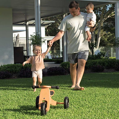 A man with two kids walking on lush green lawn