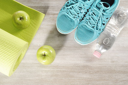yoga mat with sport shoes and healthy food on a wooden background.jpg