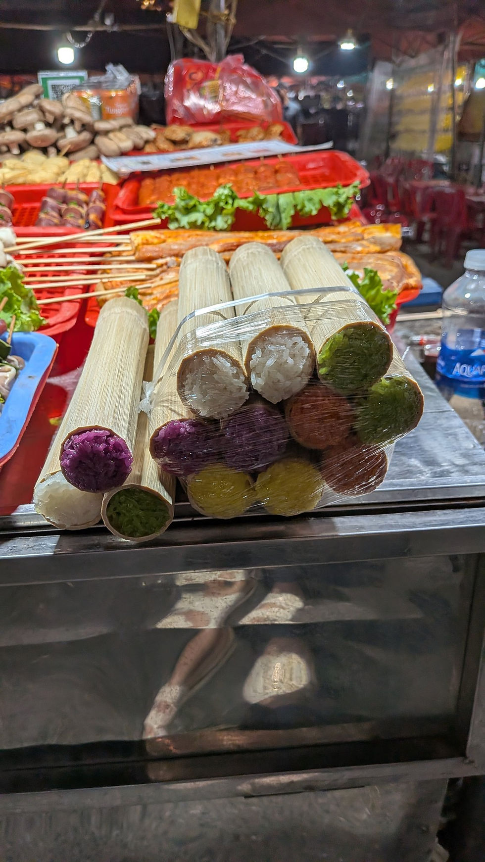 Bamboo tubes filled with colorful sticky rice on a stall