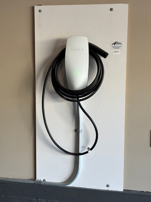 Tesla EV charger installed on garage wall