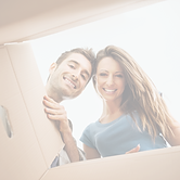Smiling young couple opening a carton bo