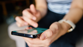 A close up of woman's hands scrolling social media feed on phone. Suggesting engagement with digital content.