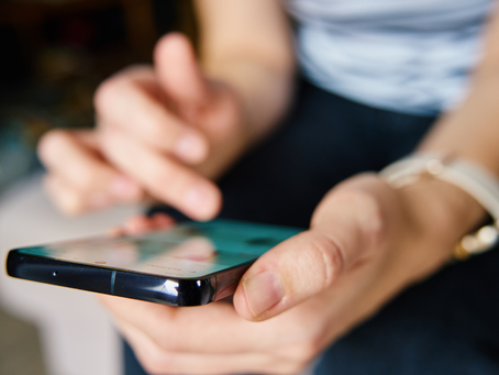 A close up of woman's hands scrolling social media feed on phone. Suggesting engagement with digital content.