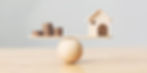 Financial Fortress_Wooden home and money coins stack on wood scaleArtboard 1