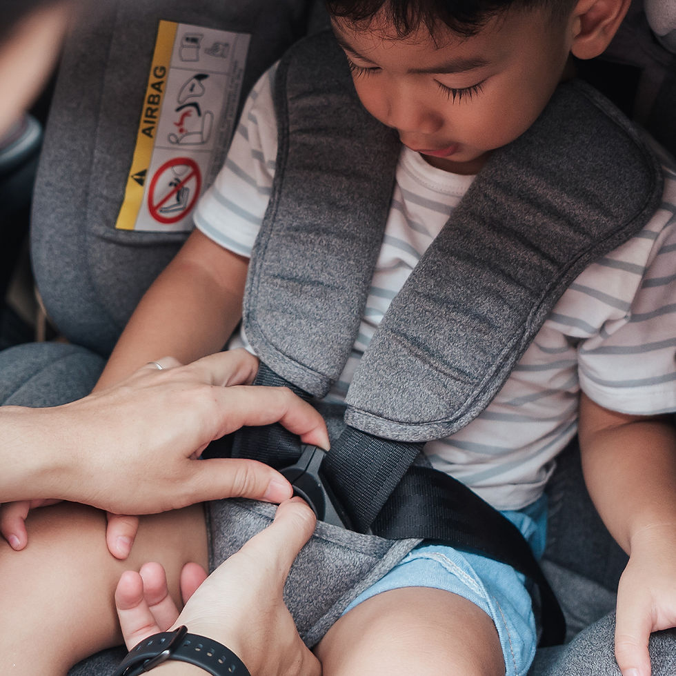 Mom strapping child safely into car seat before departure. Real-life family travel preparation scene highlighting child 