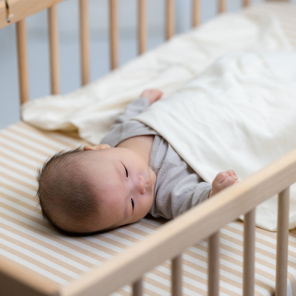 Baby relaxing on soft mattress in crib
