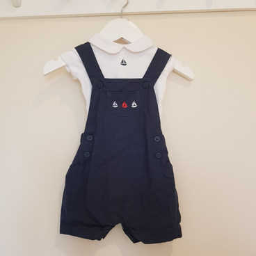 Up to one month. Navy romper and collared vest.