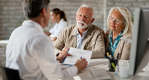 senior-couple-consulting-with-healthcare-worker-about-their-insurance-policy-while-having-