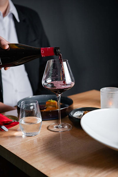 Im Restaurant & Weinbar in Berlin Schöneberg genießen Gäste glücklich Wein.