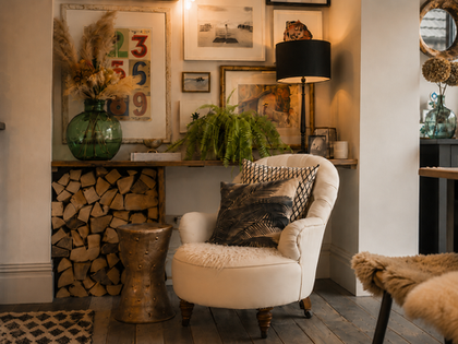 Cozy living room with armchair and decorative elements.