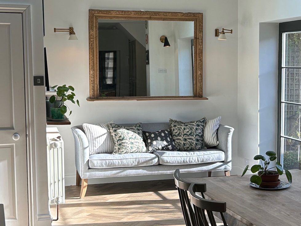 a large mirror hangs above a couch in a living room